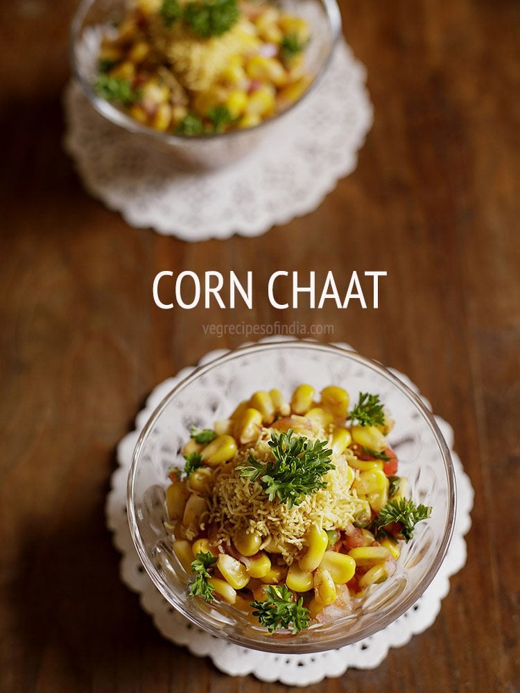 corn chaat served in a glass bowl garnished with parsley leaves. 