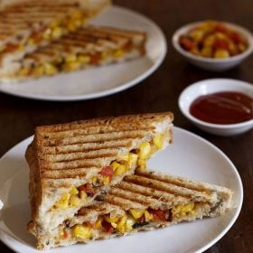 cheese corn sandwich served on a white plate with tomato ketchup