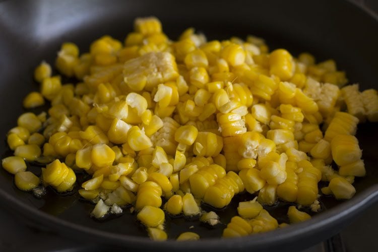 oil, minced garlic and corn kernels in a pan