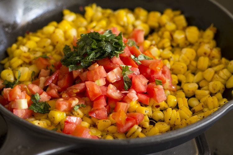 seasoned corn with tomatoes and basil leaves