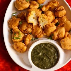 gobi pakora served in a white plate with green chutney