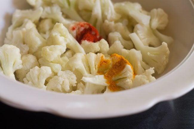 red chilli powder and turmeric added to cauliflower florets