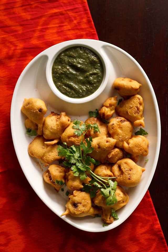 gobi pakora served in a white plate with green chutney