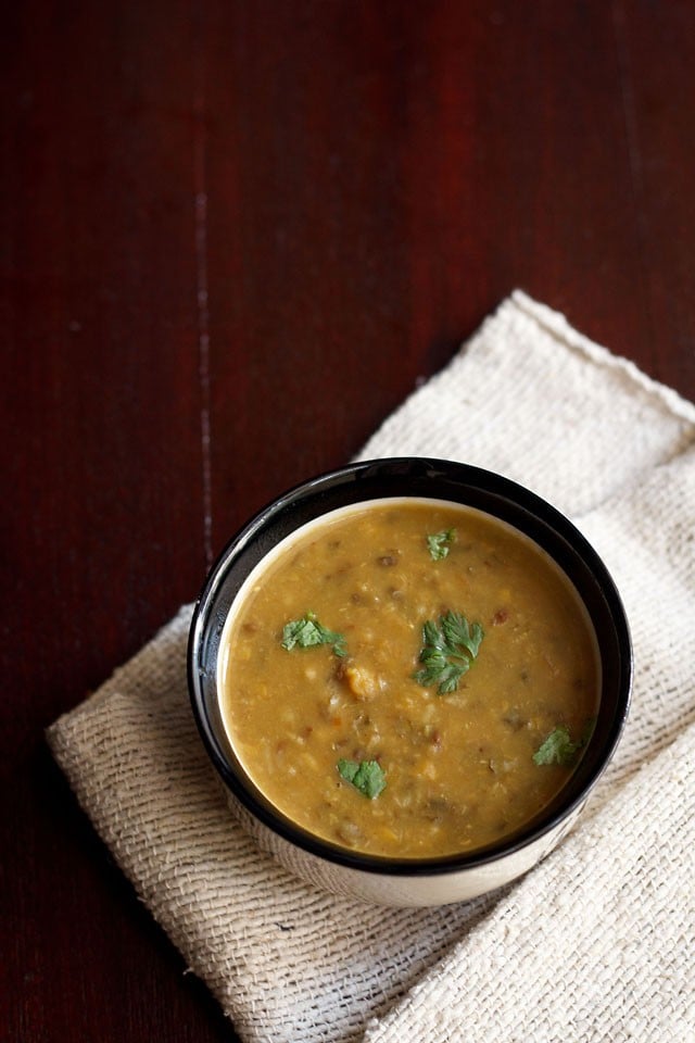 maa chole ki dal garnished with coriander leaves and served in a black bowl.