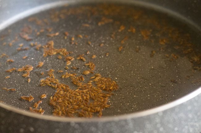 cumin seeds crackling in oil in a pan.