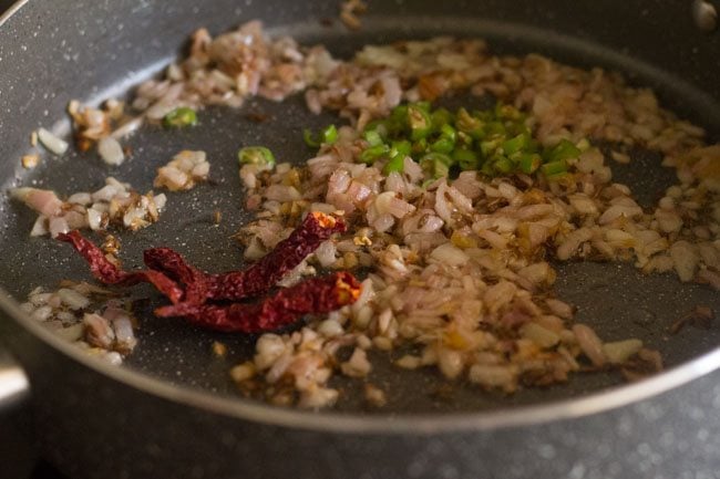 chopped green chillies and red chillies in pan with the onions.