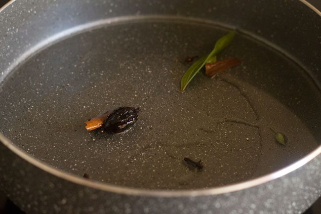 frying the spices in pan for methi chole