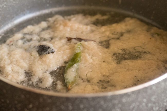 stirring onion paste in pan