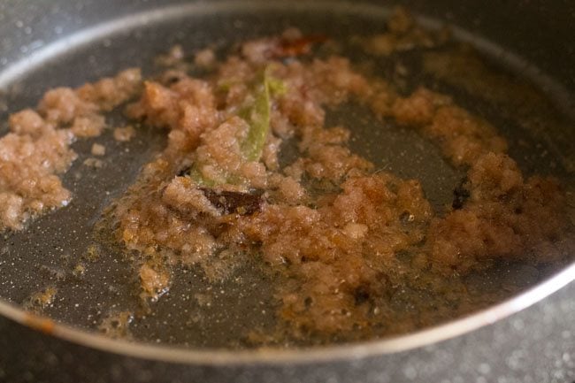 frying onion paste in pan