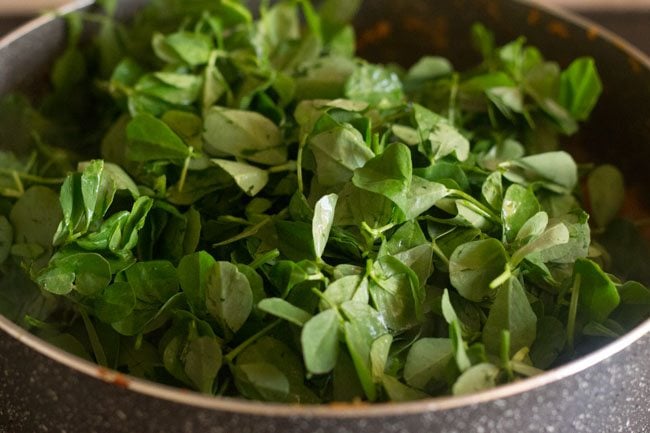 adding methi leaves in pan