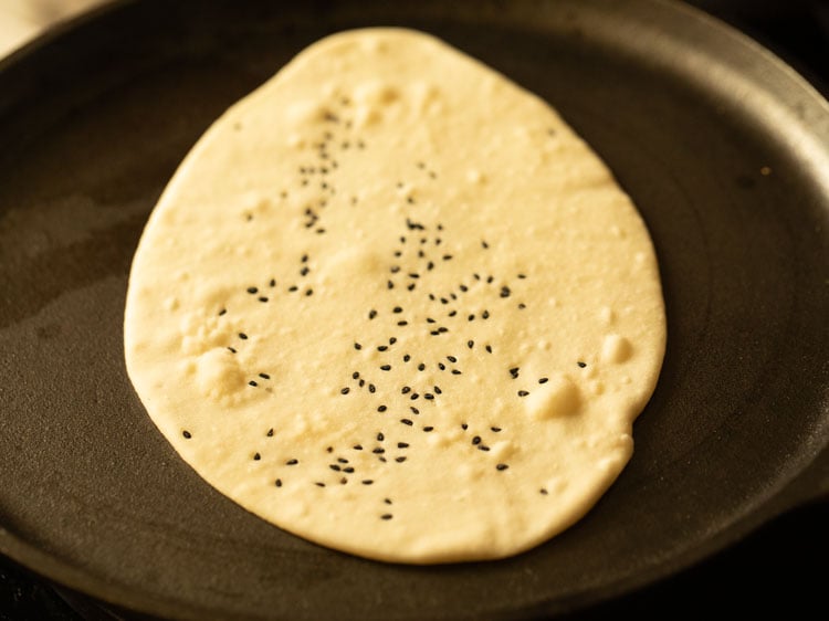 place rolled naan bread on skillet
