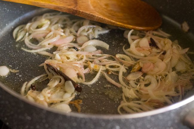 mixing sugar with onions in the pot. 