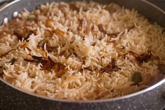 cooked parsi brown rice garnished with reserved caramelized onions. 