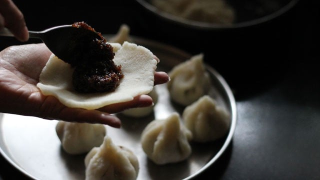 adding sweet filling to flattened dough ball