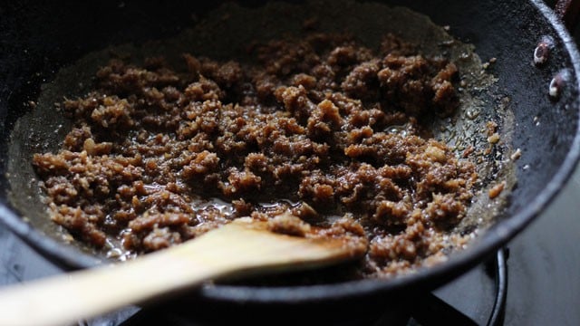 jaggery and coconut filing getting cooked in the pan