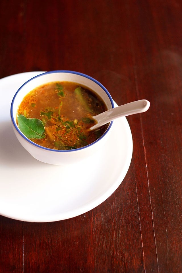 tamarind rasam served in a bowl on a white tray