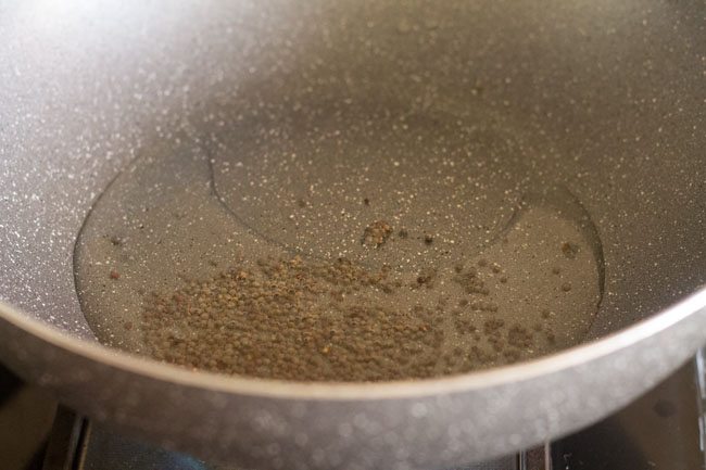 mustard seeds in oil in a kadai