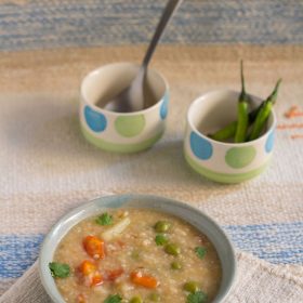 dalia khichdi served in a bowl with a spoon in it.