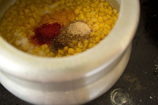 spice powders, sugar, salt and water added to pressure cooked dal for making dal pakwan recipe. 