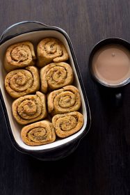 overhead shot of pull apart garlic bread in the baking crockery next to a mug of tea.