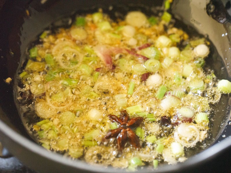 chopped spring onions being sautéed