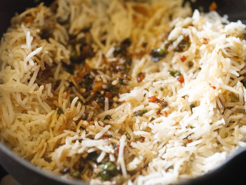 rice being mixed with stir fried vegetables