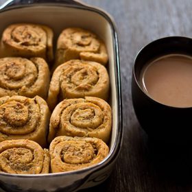 pull apart garlic bread in the baking crockery next to a mug of tea.