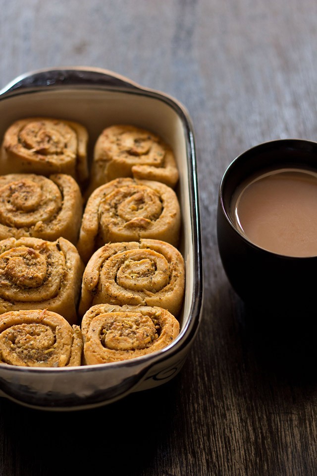 pull apart garlic bread in the baking crockery next to a mug of tea.