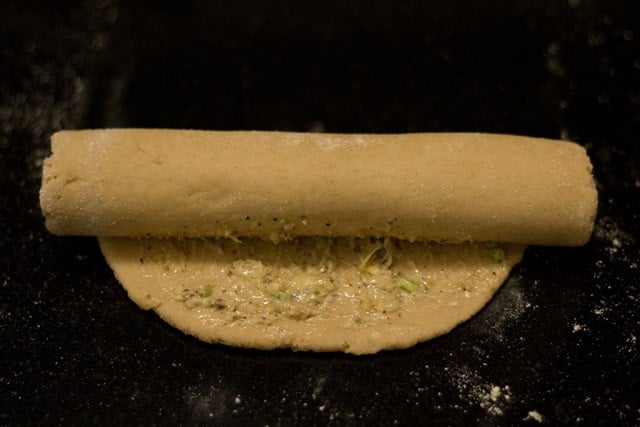 roll the bread into a tight spiral over the garlic butter.