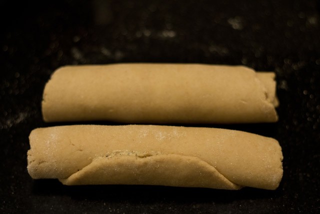 both pieces of dough have been spread with garlic butter and rolled into batons.