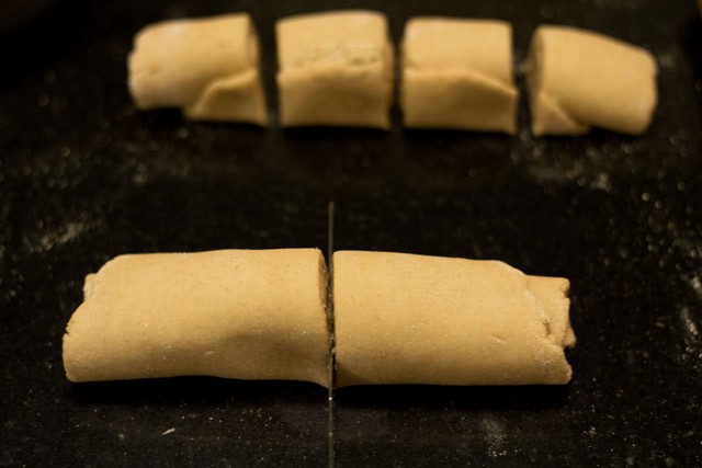 slicing logs of garlic bread rolls - you should end up with 8 even pieces.