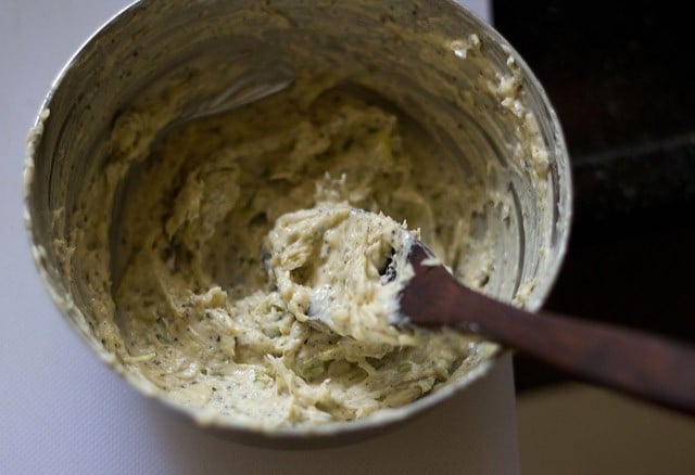 beating butter and herbs for garlic bread rolls recipe.