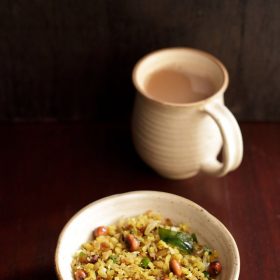 kanda poha served in ceramic bowl with a side of Indian chai in a ceramic mug