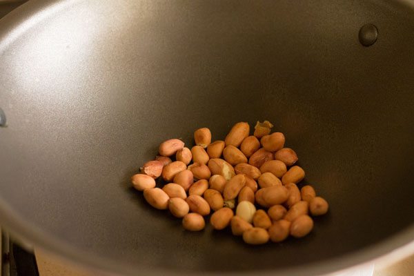 Erdnüsse werden in einer Pfanne geröstet, um Poha-Rezept zu machen