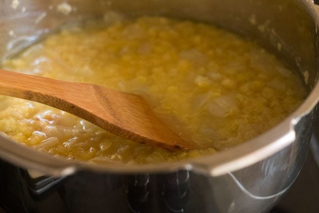 mashing the cooked tuvar dal