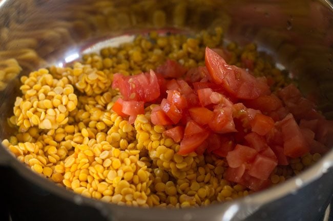 rinsed arhar dal and chopped tomato in a pressure cooker 