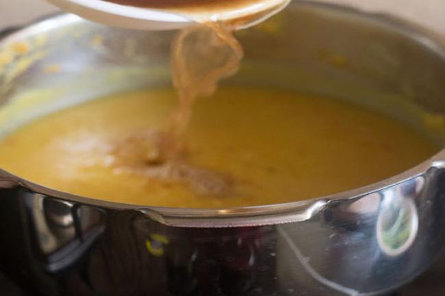 adding strained tamarind pulp to dal