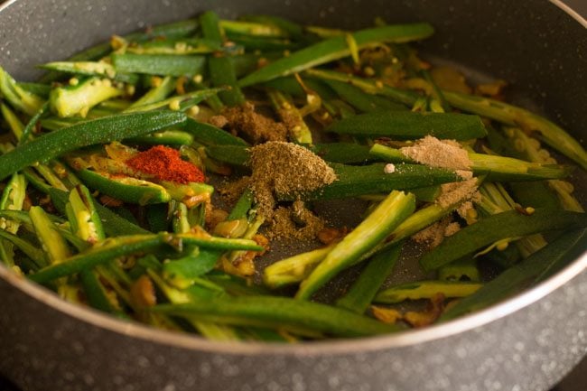adding spice powders for lahsuni bhindi