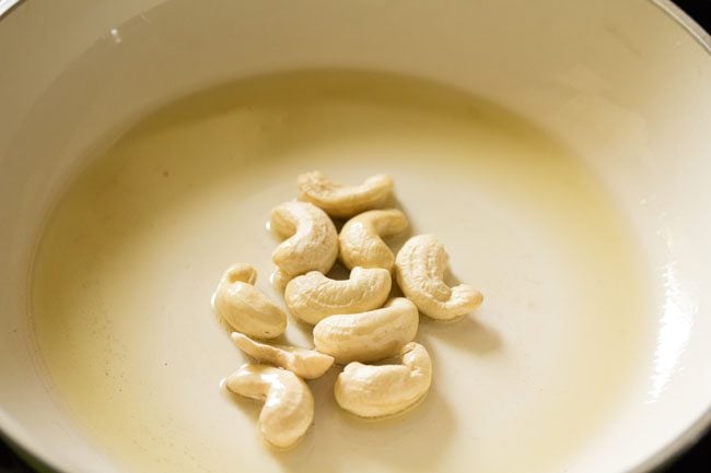 frying cashews in oil in the pan