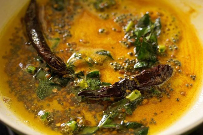 mixing spices with tempering mixture to make chitranna