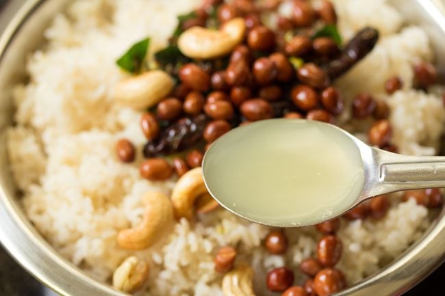 lemon juice added to cooked rice in bowl to make chitranna