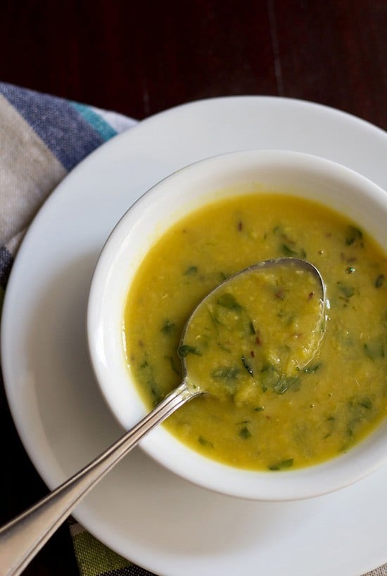 methi dal served in a white bowl with a spoon.