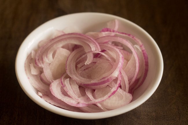 onion sliced into rings and kept in a white bowl. 