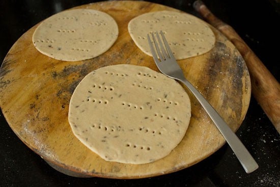 dough balls rolled into discs and pricked all over with a fork. 