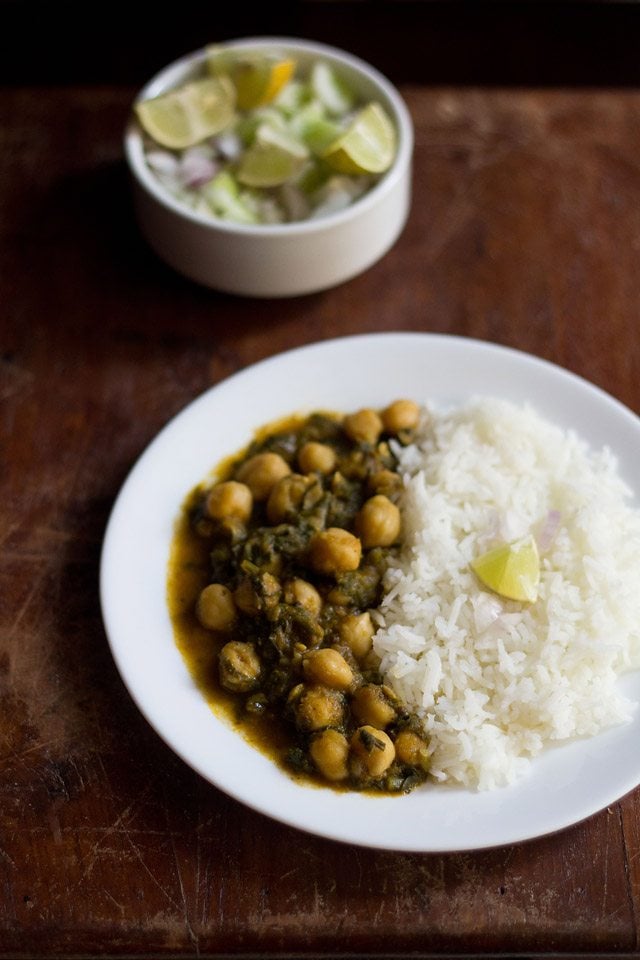 palak chole served on a white plate with steamed rice.