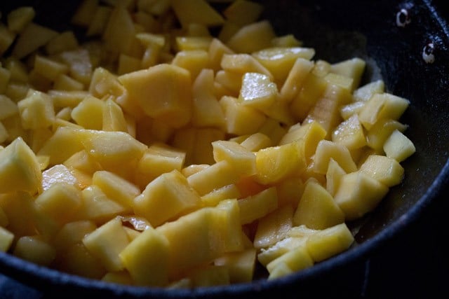 chopped semi ripe papaya in hot oil in a pan. 