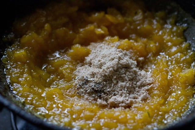 almond powder and cardamom powder added to the mashed papayas in the pan.
