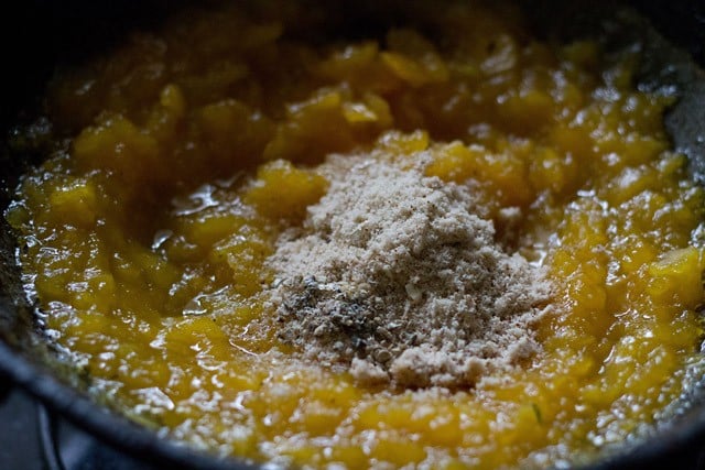 almond powder and cardamom powder added to the mashed papayas in the pan. 