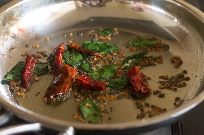 frying curry leaves and red chilies