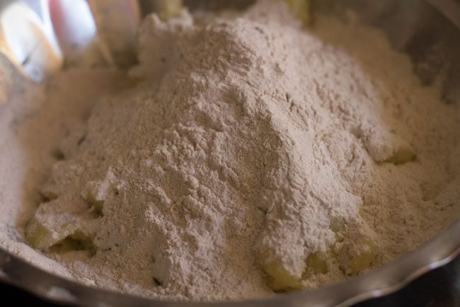 adding singhara flour on the potatoes